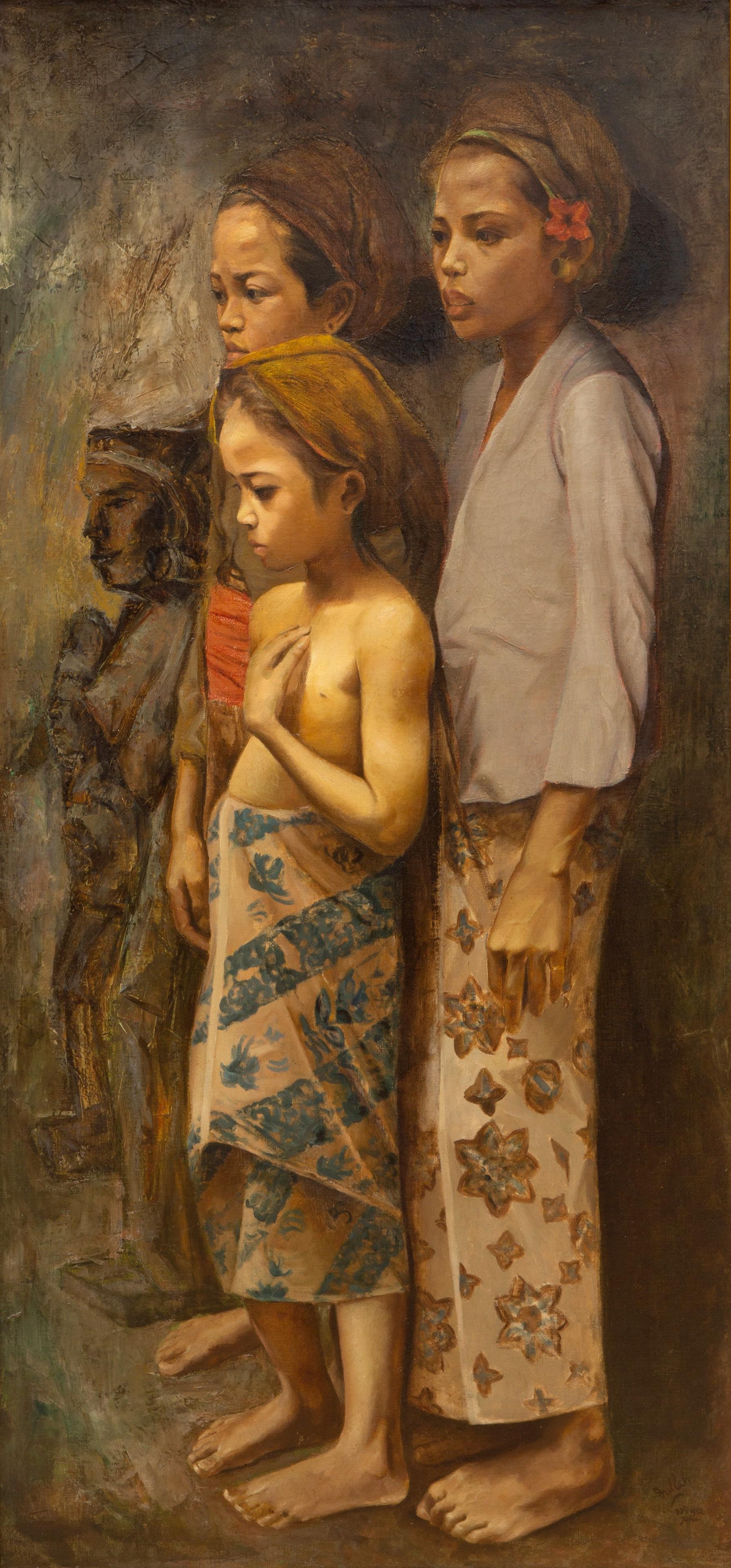 Two children and an adolescent standing next to two statues